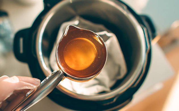 Поместить пакетик с растительной массой в мультиварку, а сверху налить мёд Процесс приготовления канна-настойки